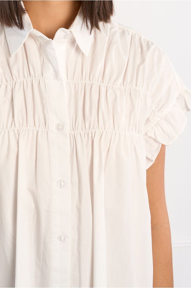 Vestido corto, camisero, con pliegues.