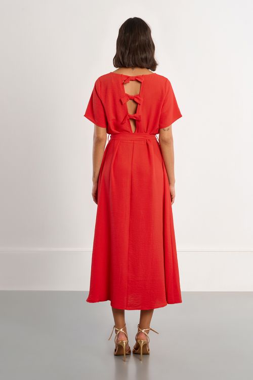 Vestido largo, con lazada y aberturas en la espalda.