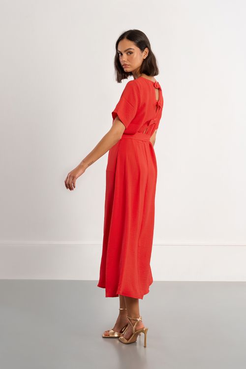 Vestido largo, con lazada y aberturas en la espalda.