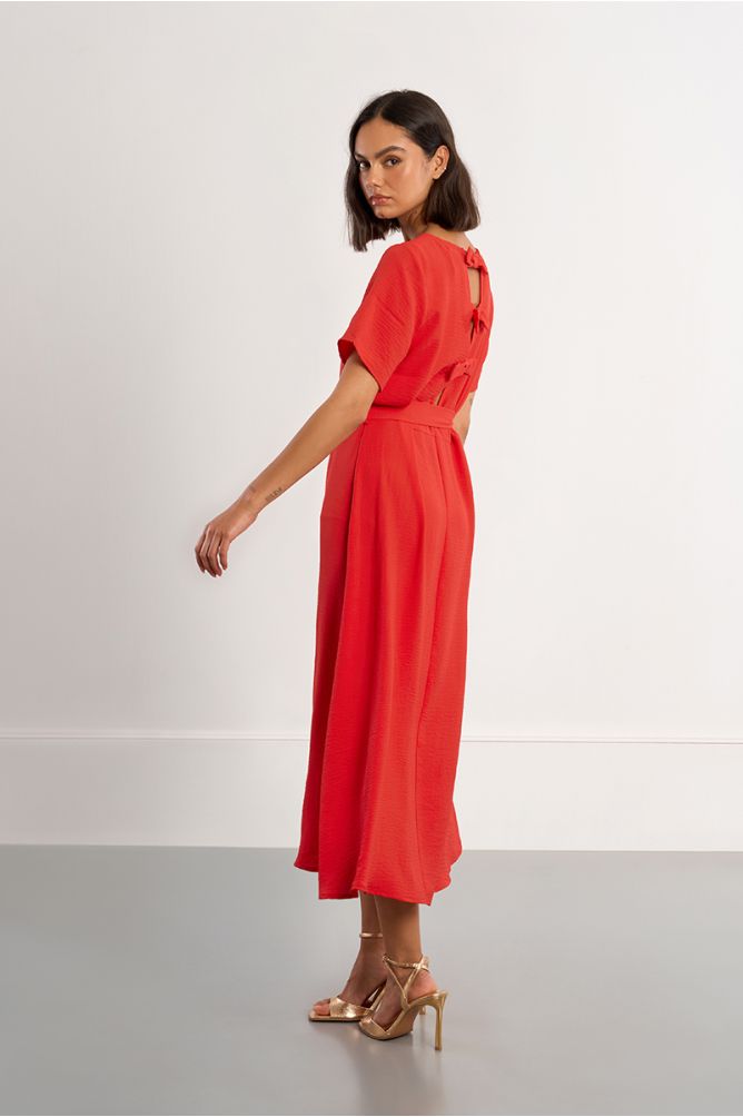 Vestido largo, con lazada y aberturas en la espalda.