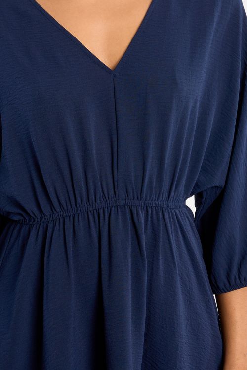 Vestido corto, de manga larga, detalle pliegues.