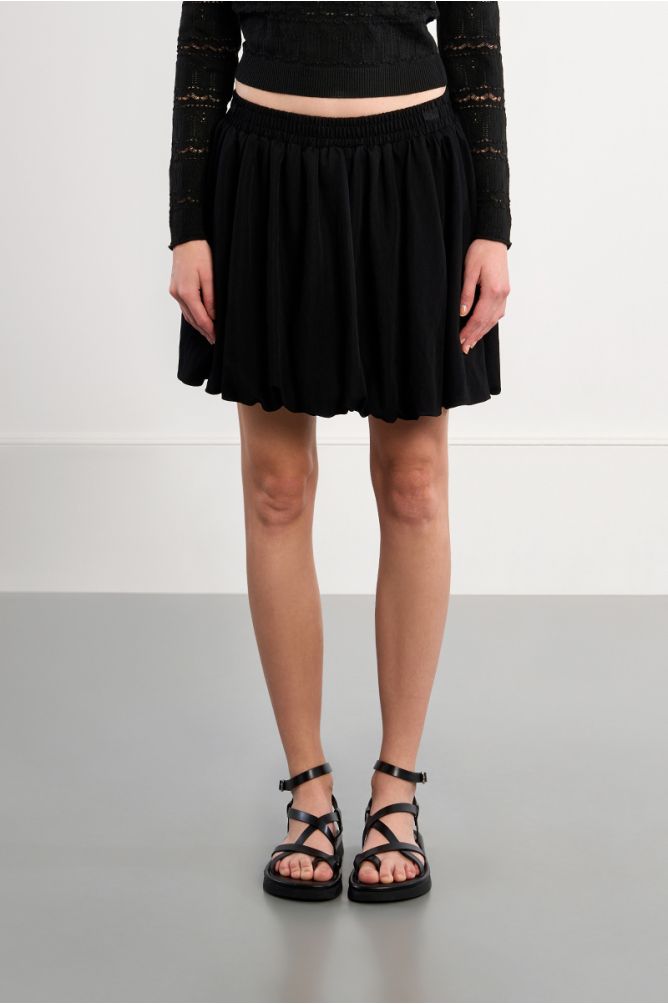 Falda corta, con pliegues.