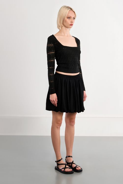 Falda corta, con pliegues.