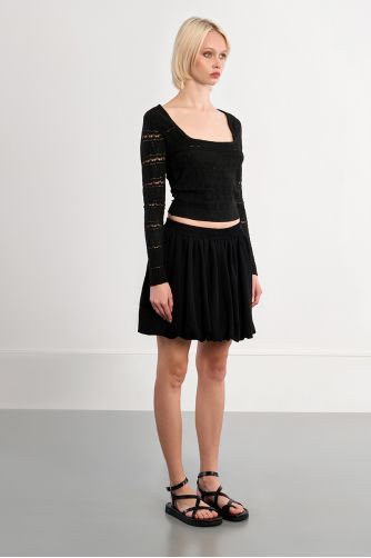 Falda corta, con pliegues.