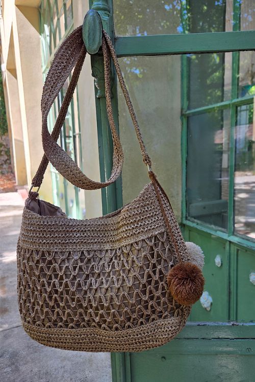 Bolso de mujer de rafia, detalle borlas.