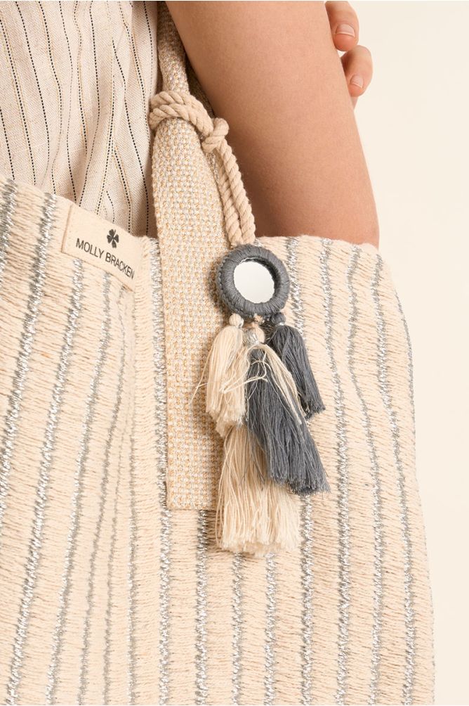 Bolso de mujer de tela, con estampado y borlas.