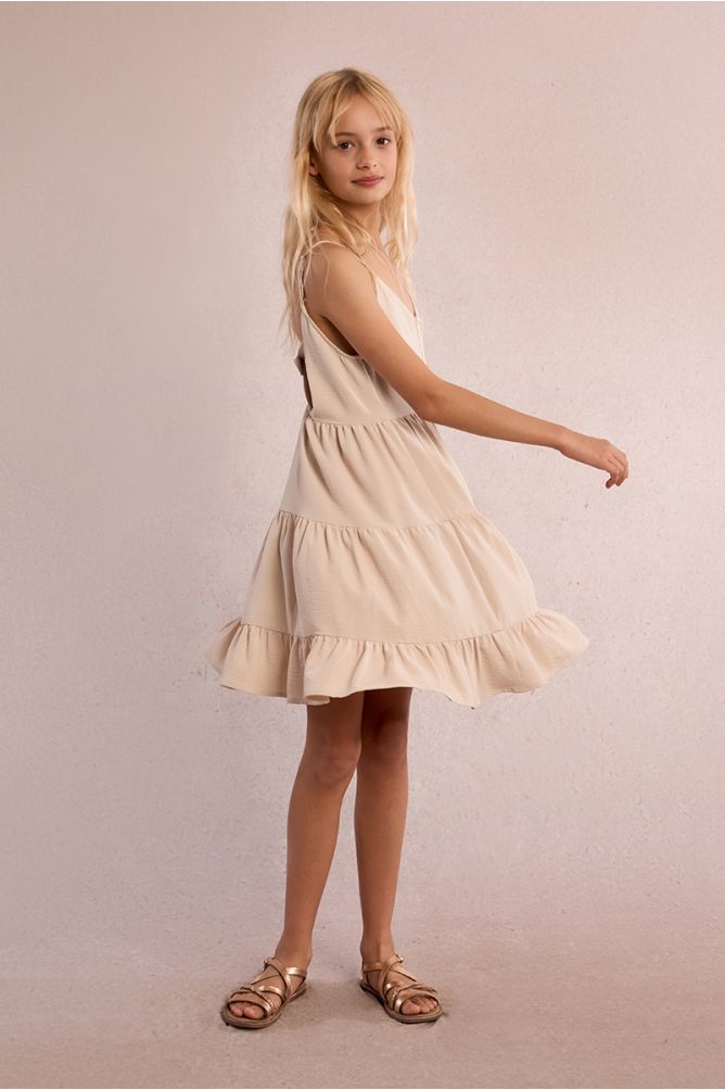 Vestido de niña de tirantes, con volantes y lazada.