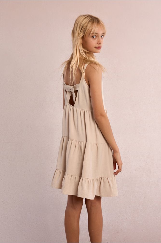 Vestido de niña de tirantes, con volantes y lazada.