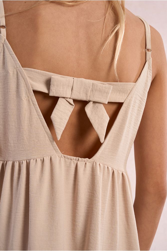 Vestido de niña de tirantes, con volantes y lazada.