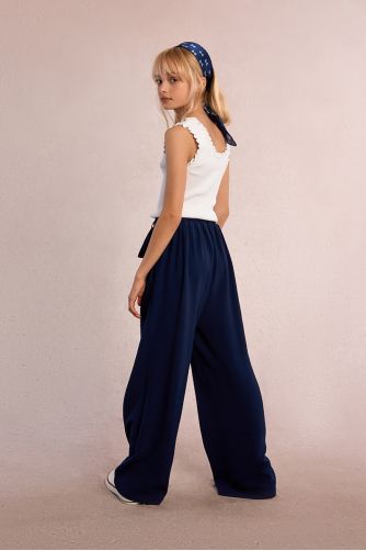 Pantalón de niña largo, con pliegues y lazada.