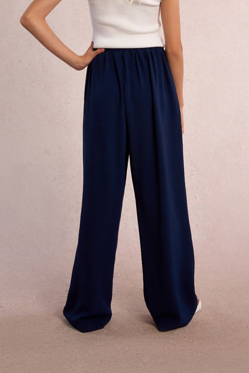 Pantalón de niña largo, con pliegues y lazada.